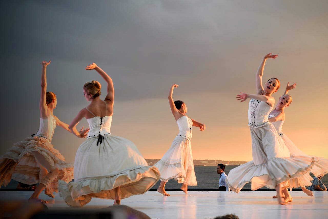 portfolio-03 Elegant ballerinas performing a captivating dance at sunset outdoors.